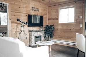 Relax in the inviting living room, complete with a sofa, electric fireplace, and Roku TV for entertainment.