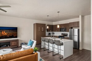 Beautifully designed living room. 75" TV, leather sleeper sofa and amazing views of mountains and city skyline.