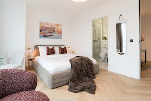 Bed and en-suite bathroom - the bathroom is attached to the sleeping space, for a luxurious feel, and easy access to the amenities.