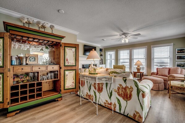 Kick back in the spacious living room with plush seating and a fabulous wooden beverage cabinet stocked with glassware—perfect for crafting your favorite cocktails.