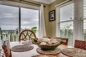 Charming dining table for 6, nestled by windows with stunning inlet views and a sliding door that leads straight to the back deck.