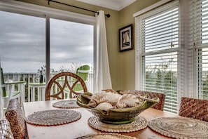 Charming dining table for 6, nestled by windows with stunning inlet views and a sliding door that leads straight to the back deck.