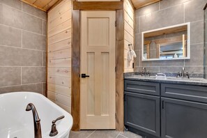 Spa-inspired en-suite with soaking tub, dual vanity and elegant rustic finishes