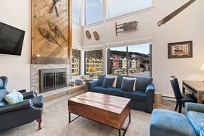 Living room with sleeper sofa, gas fireplace, smart TV, and workspace.