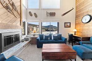 Living room with sleeper sofa, gas fireplace, smart TV, and workspace.