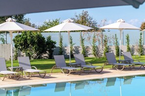 Lounge poolside under umbrellas creating a peaceful garden setting