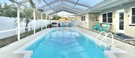 Screened-in pool, a BBQ, cocktail bar area, outdoor furniture, corn hole boards