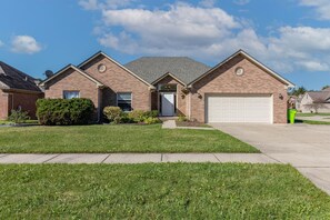 This elegant property boasts a well-manicured landscape and a spacious side driveway leading to a generous garage, ensuring a captivating first impression.