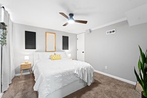Cozy bedroom with a queen bed and electrical fireplace.
