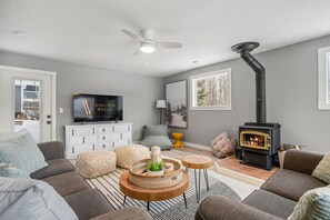 Living room with a wood-burning fireplace, board games, a Smart TV, cozy seating & more. There's also a single rollaway cot (with bedding) for additional sleeping space.