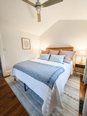 Cozy queen bed in open space — no door, just comfort and charm.