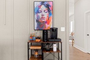 Coffee bar includes  a keurig coffee maker, a pour-over coffee maker, a french press + regular coffee, coffee pods, tea, sugar, cream, and sweetener.