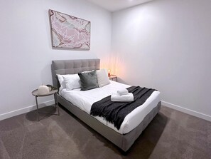 The second bedroom with a queen-sized bed and plush pillows.