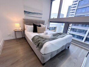 The master bedroom with a queen-sized bed and plush pillows.