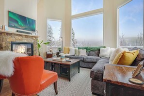 The great room living room at Skalli Haus with flatscreen tv, sonos sound bar, two-way gas fireplace, board games, and massive windows with views of the surrounding peaks.  A great place to start the party before heading to the Game Room.