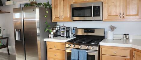 Full-sized appliances and cookware in kitchen.