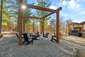A cozy firepit area complete with Adirondack chairs, a saucer swing, and a bench swing—perfect for everyone to gather, relax, and create unforgettable memories around the fire.