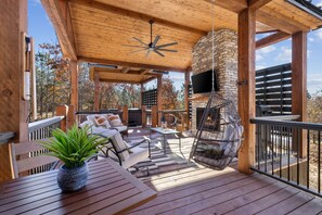 Step onto the back porch retreat, where cozy seating invites you in the beauty of the outdoors. Enjoy the warmth of the fireplace, unwind in hot tub, sway on swings, dive into games—all coming