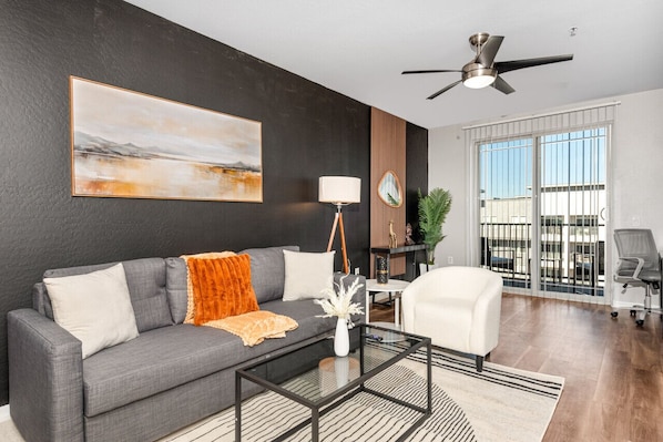 Stylish living room with comfortable double sofa bed, working station and private patio.