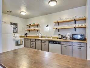 View of the fully loaded upgraded kitchen with open shelving and new flooring