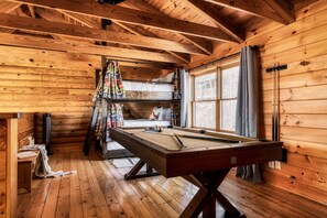 The upstairs loft offers a full-sized pool table and custom bunks