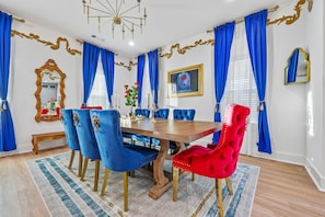 Elegant Dining Space for Memorable Gatherings "Step into a Beauty & the Beast-inspired dining room with royal blue drapes, vibrant red chairs, and golden accents that create the perfect setting for unforgettable moments. #LuxuryDining #ThemedHomes #Atlanta