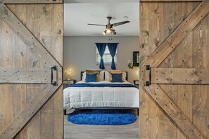 Slide open the stylish sliding barn doors to reveal the lavish master bedroom 