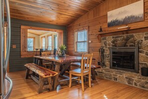 Cozy kitchen with granite counters, green cabinets, and a handcrafted table.