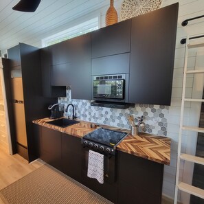 Kitchen with all your basic cooking needs. Includes plates and utensils.