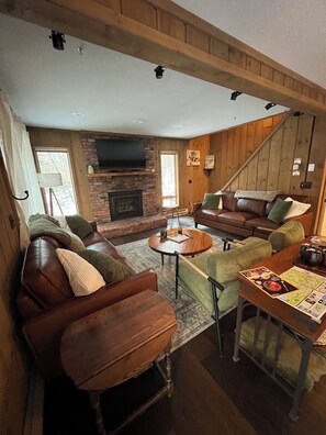 Cozy main level living room has seating for 8, a gas fireplace, and smart tv.