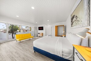 Unwind in this spacious bedroom featuring a luxurious king-size bed, cozy sofa, large windows with natural light, Netflix for endless entertainment, and an open closet for easy access to your wardrobe, all complemented by refreshing air conditioning.