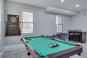 Fun-filled game room featuring a pool table, dartboard, and additional gaming options. Bright and inviting, perfect for hours of entertainment.