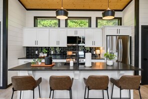 Modern meets rustic in this stunning kitchen with sleek black accents and warm wood tones.