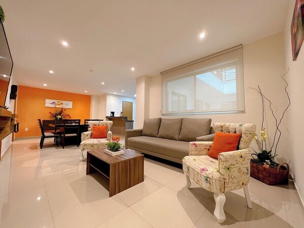 Disfruta de una película en la tv en la sala moderna que se integra perfectamente con el comedor, facilitando un espacio social abierto y acogedor ¡Te sentirás como en casa!