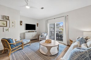 Living room with sleeper sofa, smart TV and balcony with dining table