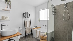 Indulge in a spa-like experience with a beautifully designed bathroom featuring a bathtub, shower and all the comforts you need.