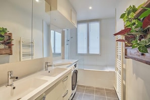 Salle de bain avec double vasque et baignoire