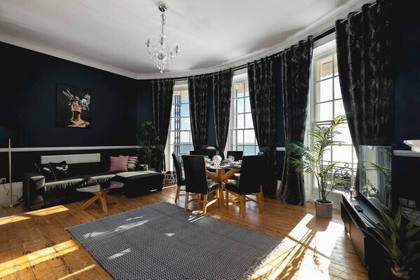 Elegant seafront apartment with stunning bay windows, rich velvet curtains, chic décor, and a bright open-plan lounge. Perfect for relaxing in style in Brighton