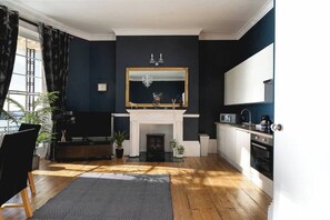 Chic open-plan living space with period features, fully equipped kitchen, and elegant fireplace—perfect for stylish stays in central Brighton.