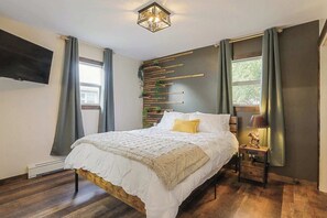 Custom accent wall with plants - Queen size bed  - Premium mattress  - Premium bedding  - Pinched duvet  - Room darkening curtains - Moose lamp -45" Roku Smart TV - Streaming ability - Cable - USB and outlet Charging Station on nightstand
