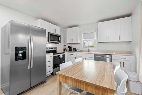 Enjoy a fully equipped kitchen with full-size appliances and a dining table for four, perfect for home-cooked meals and gatherings.