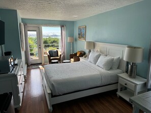 A serene bedroom with large windows that bring in natural light and offer peaceful views.