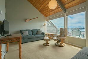 This cozy living area features vaulted ceilings and expansive windows, offering stunning views and natural light.