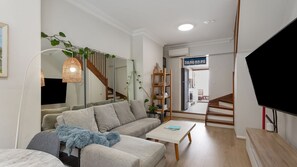 Relax in style with a cozy couch, dining area, and sleek mirrors.