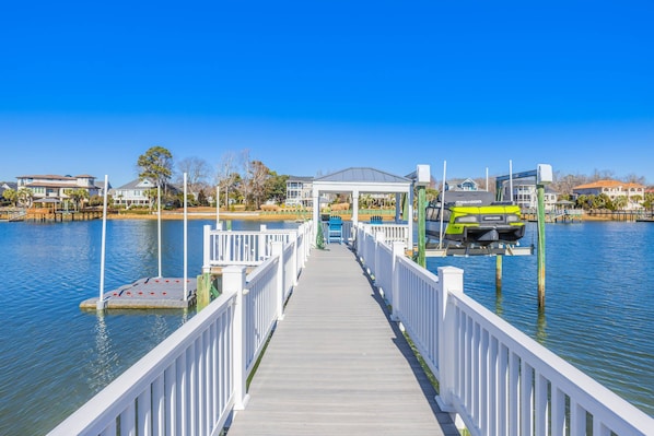 Scenic dock with a covered seating area, jet ski dock and serene waterfront views. (Boat lift not available for use)