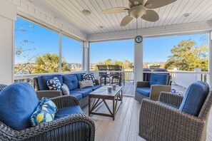 Inviting screened porch and an uncovered deck, both with ample seating. Enjoy scenic views and a gentle breeze, perfect for relaxing gatherings!
