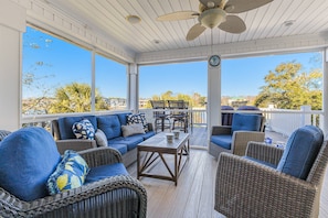 Inviting screened porch and an uncovered deck, both with ample seating. Enjoy scenic views and a gentle breeze, perfect for relaxing gatherings!