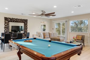 Game room with a pool table and poker table.