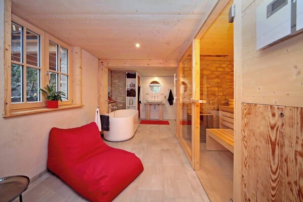 Der Wellnessbereich mit freistehender Badewanne, Sauna und Terrasse bietet Luxus und Erholung. Entspannt euch in der Badewanne mit Naturblick, genießt die wohltuende Sauna oder atmet frische Luft auf der Terrasse – der perfekte Ort für Erholung. 