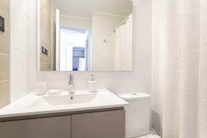 Experience modern comfort in this sleek bathroom, featuring a spacious vanity and elegant design.